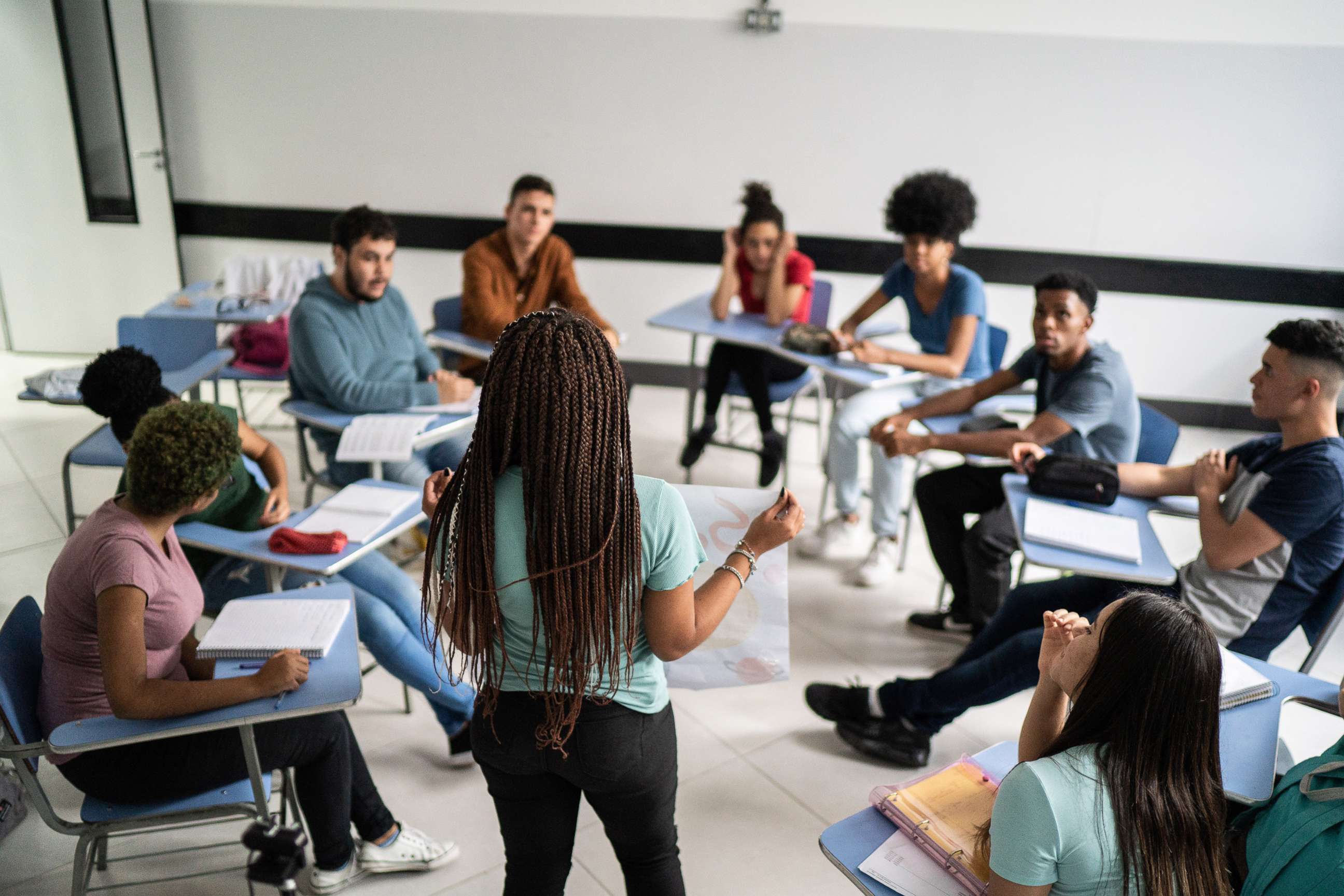 PHOTO: A teenager student speaks to fellow classmates in the classroom in a stock photo.