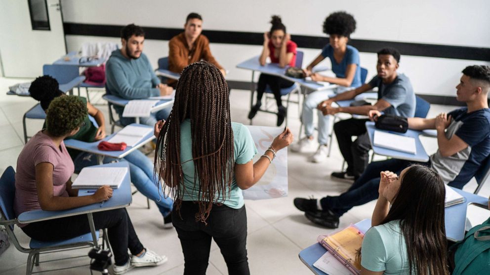 PHOTO: A teenager student speaks to fellow classmates in the classroom in a stock photo.