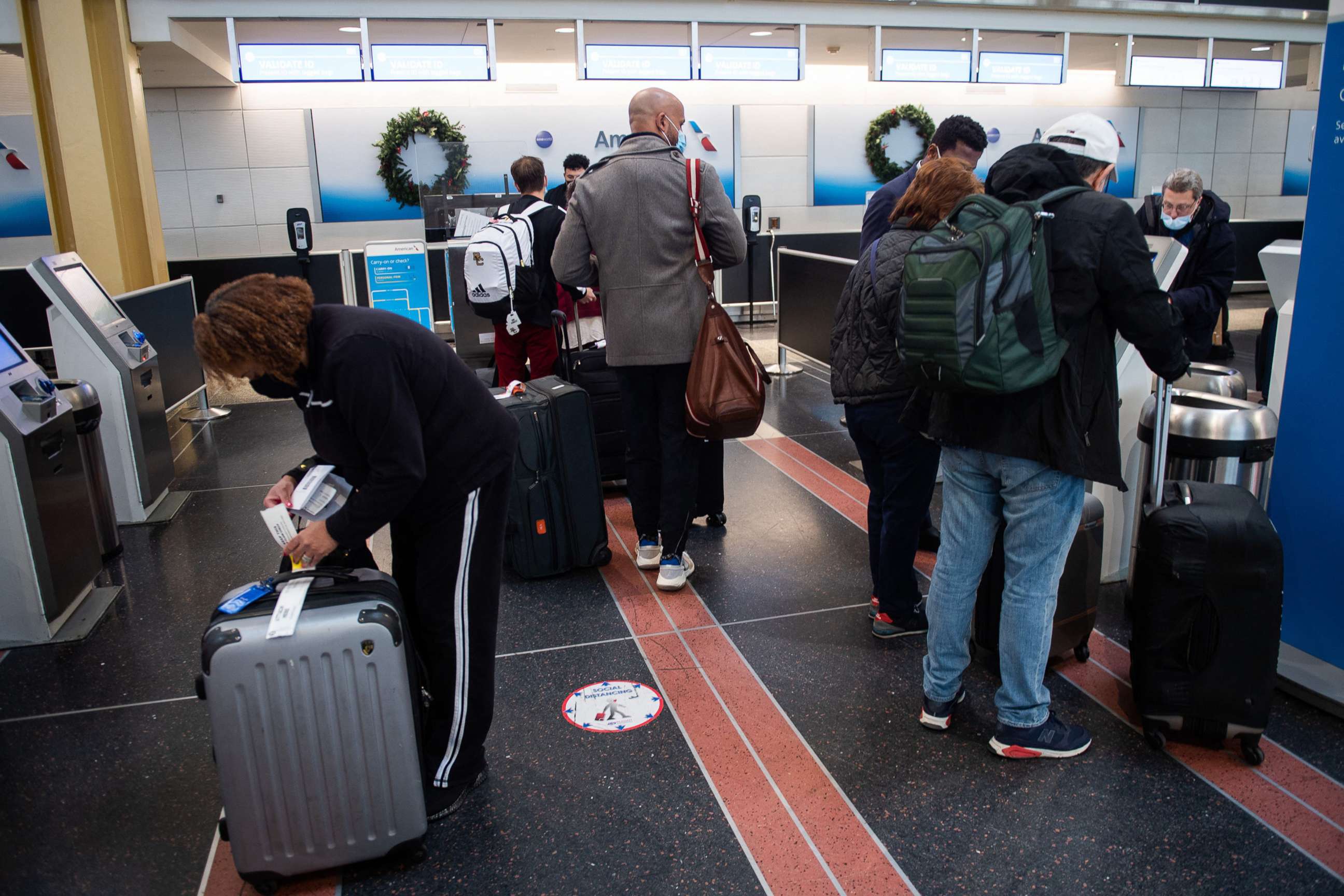 PHOTO: Travelers go through the check-in process before flying out of Ronald Reagan International Airport in Washington, D.C., Dec. 27, 2021.