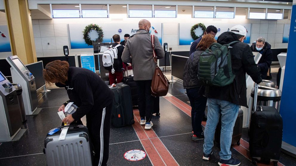 PHOTO: Travelers go through the check-in process before flying out of Ronald Reagan International Airport in Washington, D.C., Dec. 27, 2021.