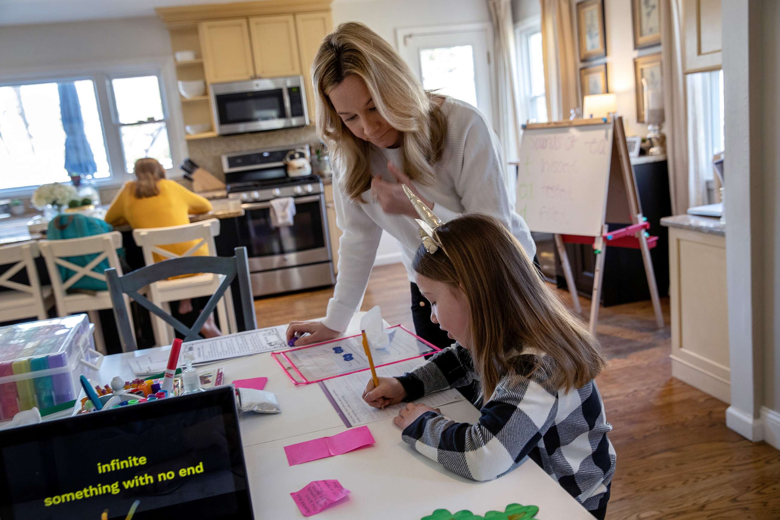 PHOTO: Farrah Eaton assists her daughter Nola, 6, with home schooling on March 18, 2020 in New Rochelle, New York.