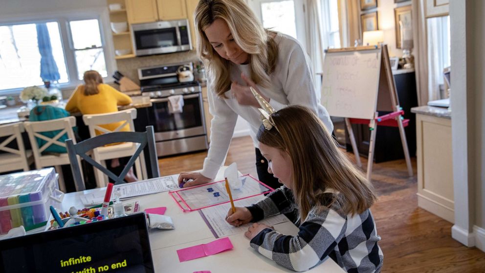 PHOTO: Farrah Eaton assists her daughter Nola, 6, with home schooling on March 18, 2020 in New Rochelle, New York.