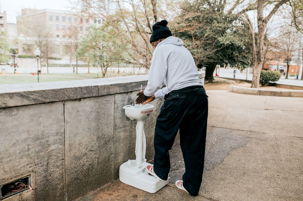 PHOTO: A man who's currently experiencing homelessness washes his hands.