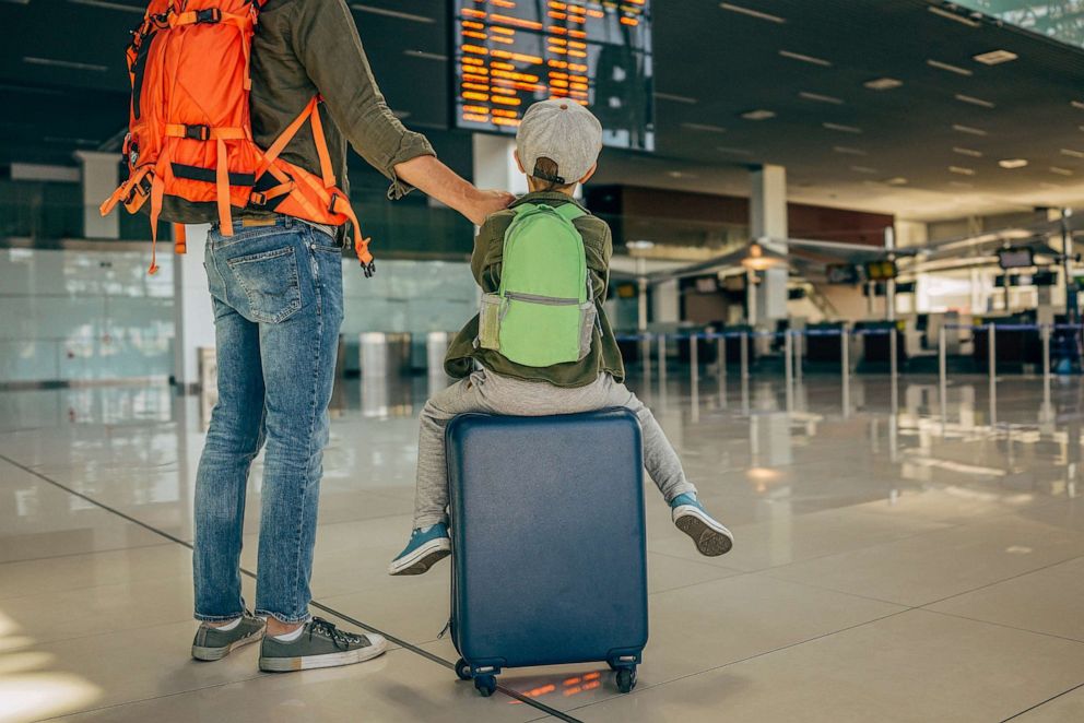 PHOTO: Photo of a cheerful little boy and his father, who travel together, waiting for their flight at the airport in this undated stock photo.