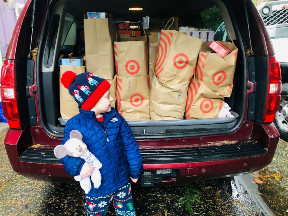 PHOTO: Hudson Galligan stands in front of a car filled with shopping bags of hot cocoa. 