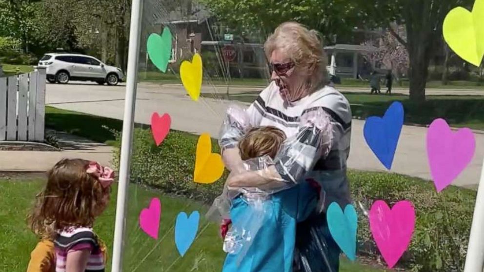 PHOTO: On May 12, Rose Gagnon, 85, hugs her great-grandchildren through a plastic 'Hug Time' shield made by Carly Marinaro in Rockford, Illinois.