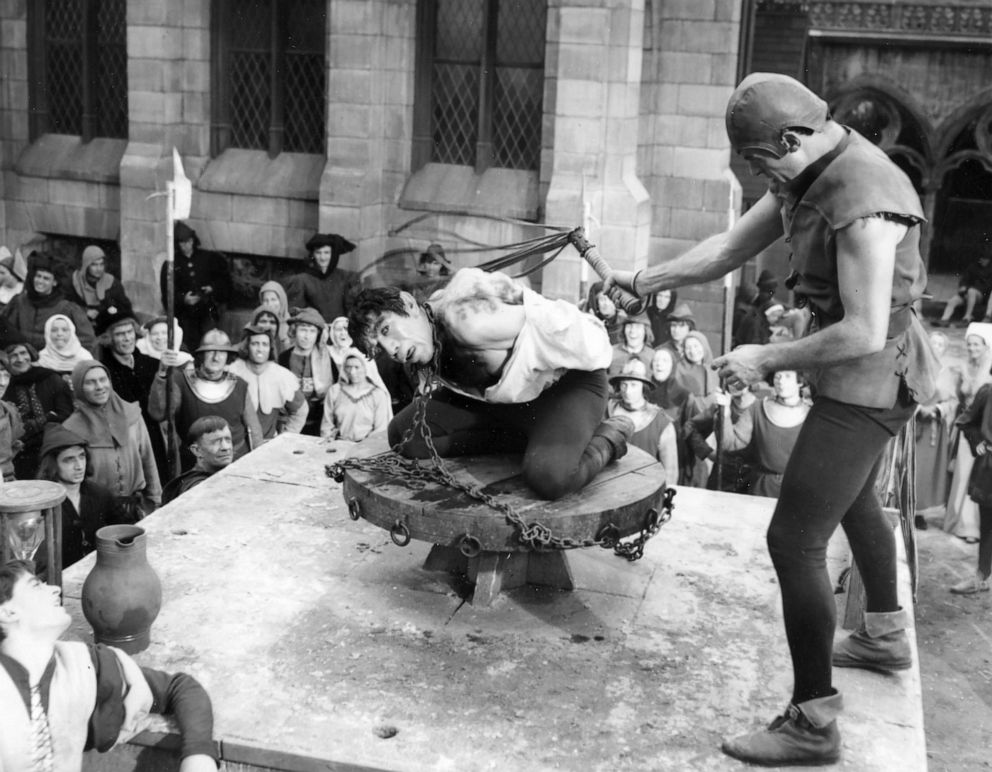 PHOTO: Anthony Quinn as the Hunchback is whipped by the hangman during filming of Victor Hugo's "The Hunchback of Notre Dame," in front of a set near Paris that replicates Notre Dame Cathedral, July 30, 1956.