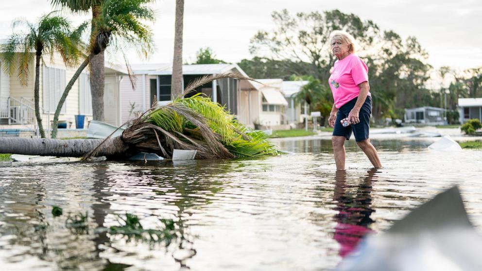 PHOTO: A woman walks along a flooded street in the aftermath of Hurricane Milton, Oct. 10, 2024, in Osprey, Fla.