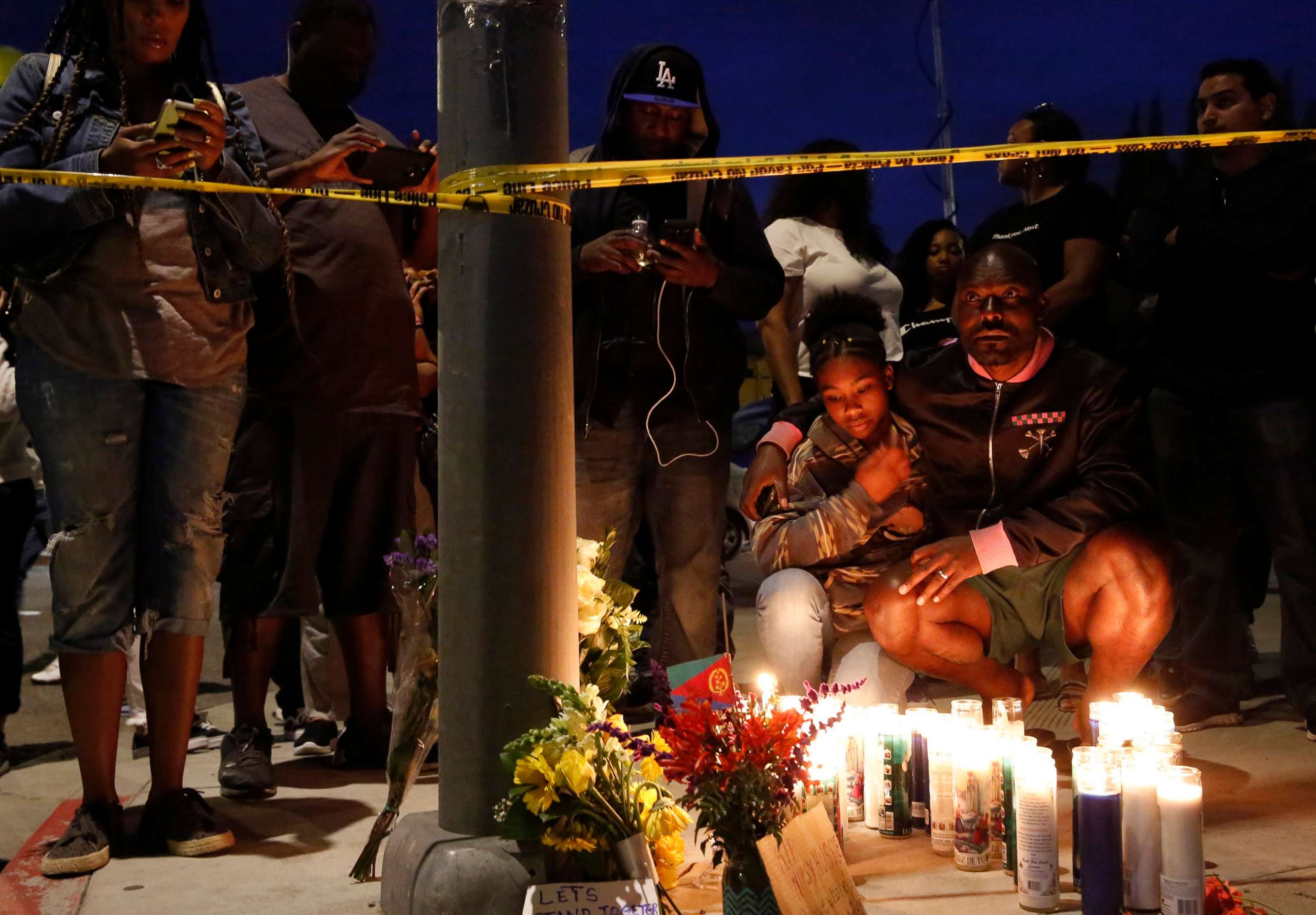 PHOTO: Haitian-French actor Jimmy Jean-Louis and his daughter Jasmin, 16, gather around candles set up across from the clothing store of rapper Nipsey Hussle in Los Angeles, March 31, 2019.