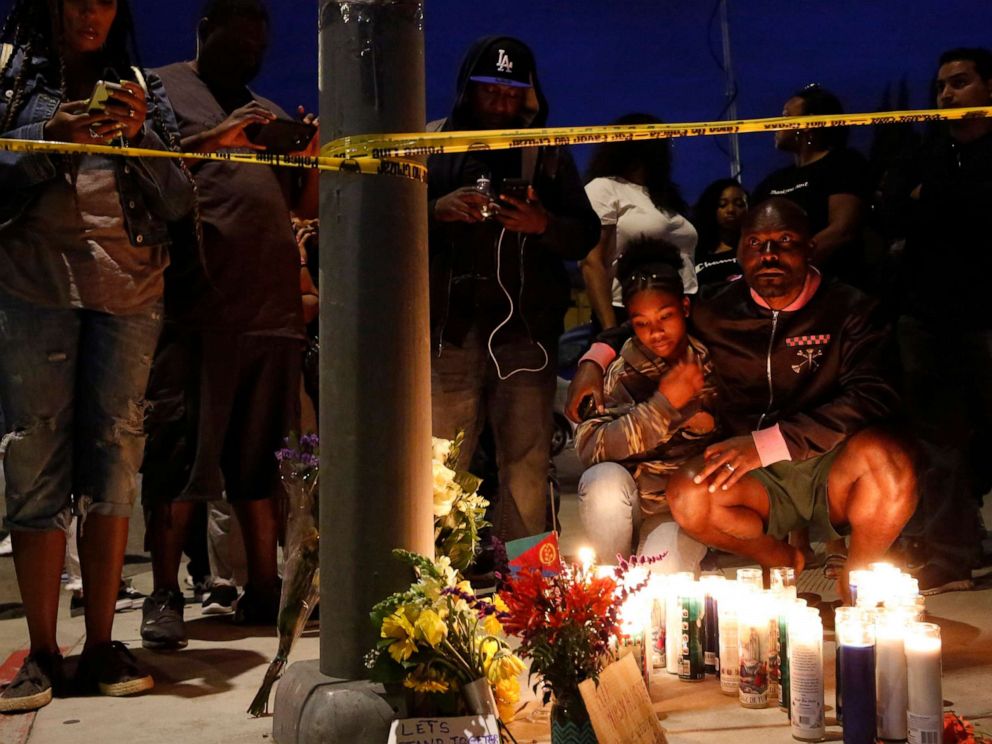PHOTO: Haitian-French actor Jimmy Jean-Louis and his daughter Jasmin, 16, gather around candles set up across from the clothing store of rapper Nipsey Hussle in Los Angeles, March 31, 2019.