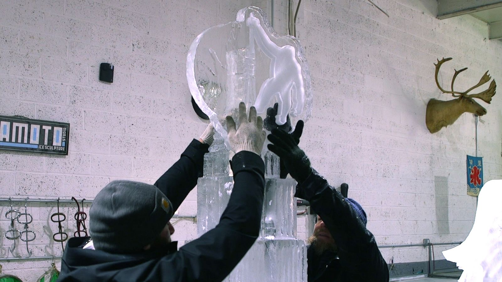 PHOTO: The final piece of an ice sculpting of the Empire State Building gets carefully laid on top.