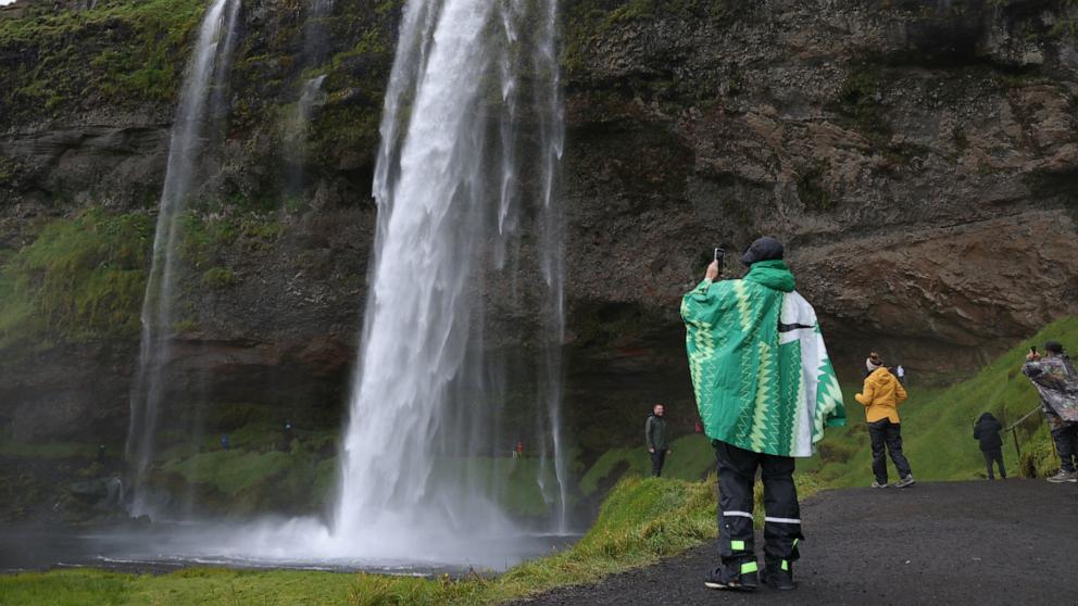 PHOTO: Tourists walk around Seljalandsfoss waterfall, Aug. 12, 2021, near Storidalur, Iceland. 