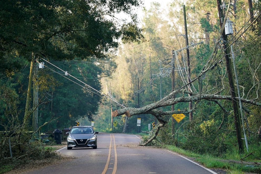 PHOTO: A motorist passes under a storm damaged utility line, Sept. 1, 2021, in Hammond, Louisiana.