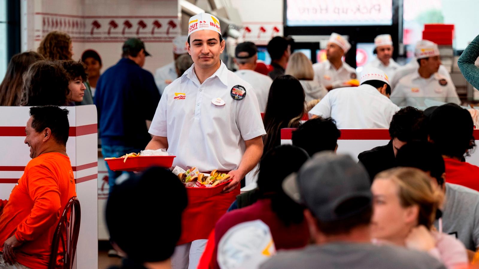 PHOTO: A worker serves diners at In-N-Out Burgers new location on Del Obispo St. in San Juan Capistrano, CA, December 7, 2023.