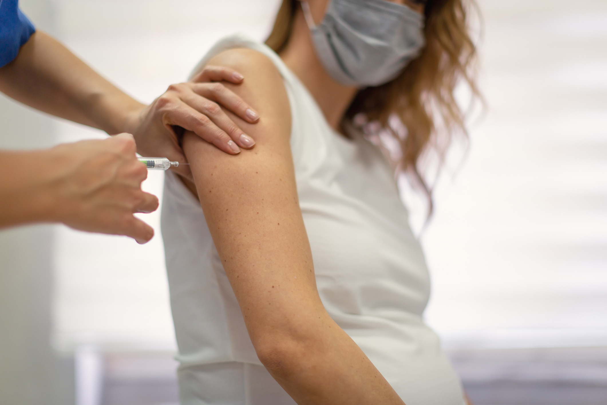 PHOTO: A COVID-19 vaccine is being administered to a woman by a medical professional in this stock image.
