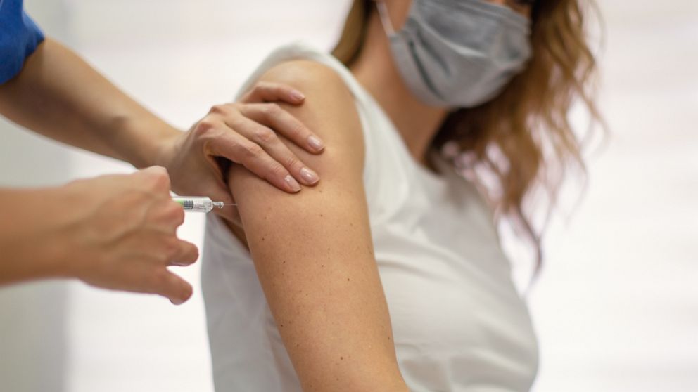 PHOTO: A COVID-19 vaccine is being administered to a woman by a medical professional in this stock image.