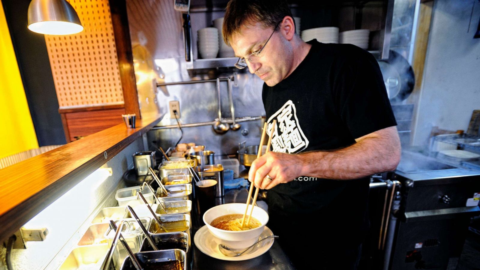 PHOTO: Ivan Orkin adds toppings of various ingredients to a bowl of ramen at Ivan Ramen in Tokyo on Friday, April 10, 2009.