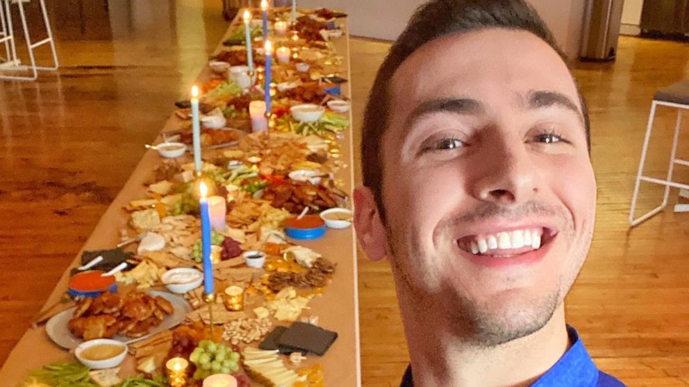 PHOTO: Jake Cohen takes a selfie with a full Hanukkah Shabbat spread.