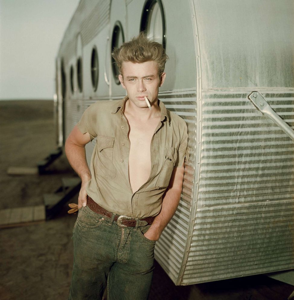 PHOTO: James Dean leans against a dressing room trailer with his shirt open to the waist while smoking a cigarette on the set of director George Stevens's 1956 film, "Giant."