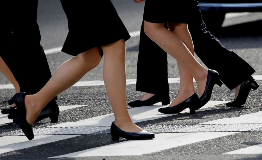 PHOTO: Women in high heels walk in a business district in Tokyo on June 4, 2019. 