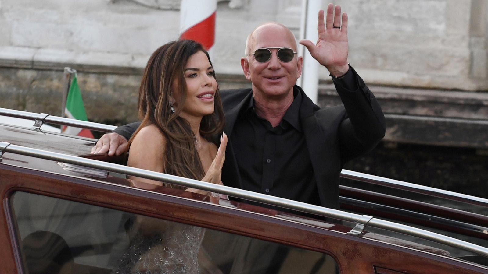 PHOTO: Jeff Bezos and Lauren Sanchez wave as they exit the Hotel Aman Wedding, June 28, 2025 in Venice, Italy.