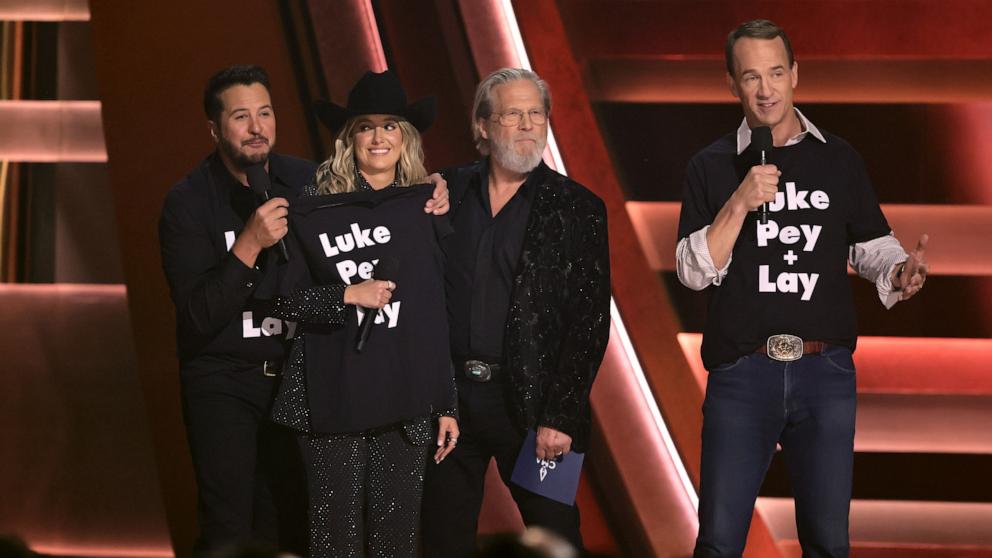 PHOTO: (L-R) Luke Bryan, Lainey Wilson, Jeff Bridges and Peyton Manning speak onstage during The 58th Annual CMA Awards, Nov. 20, 2024, in Nashville, Tenn.