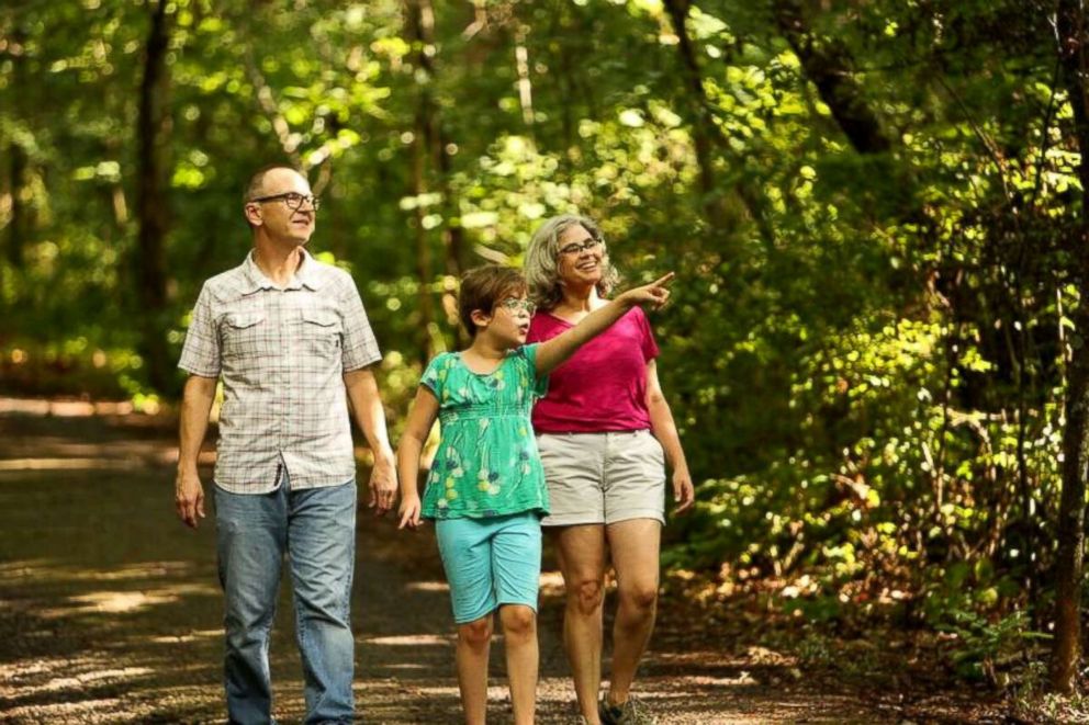 PHOTO: Jenn Gray walks with her husband, Jamie, and their daughter, Mila.