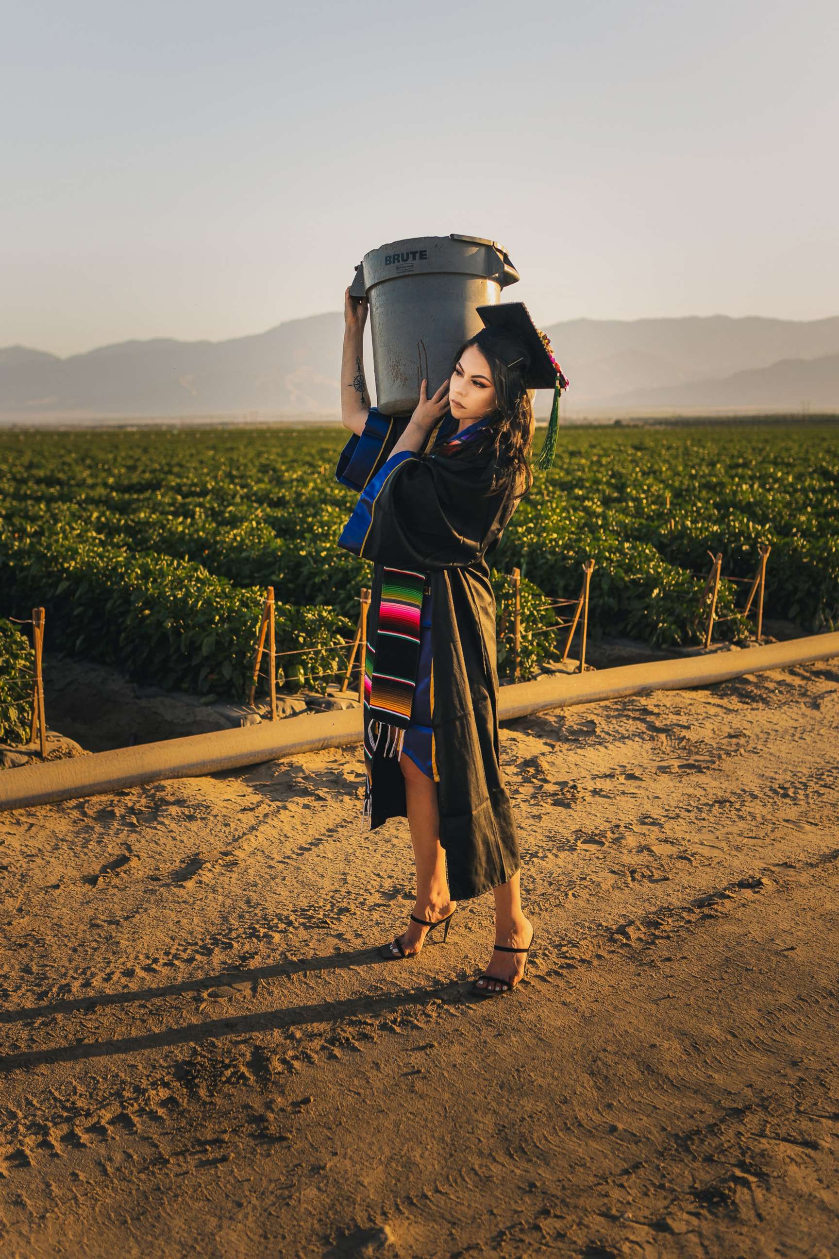 PHOTO: Jennifer Rocha, 21, a new graduate from the University of California San Diego, poses for a graduation photo in the fields where her parents worked to support her education.