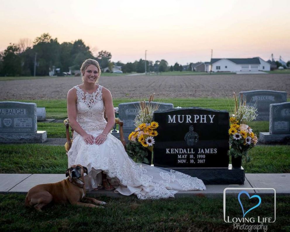 PHOTO: Jessica Padgett at Kendall Murphy’s tombstone with his dog at Providence Mennonite Church grave site in Montgomery, Indiana, Sept. 29, 2018.