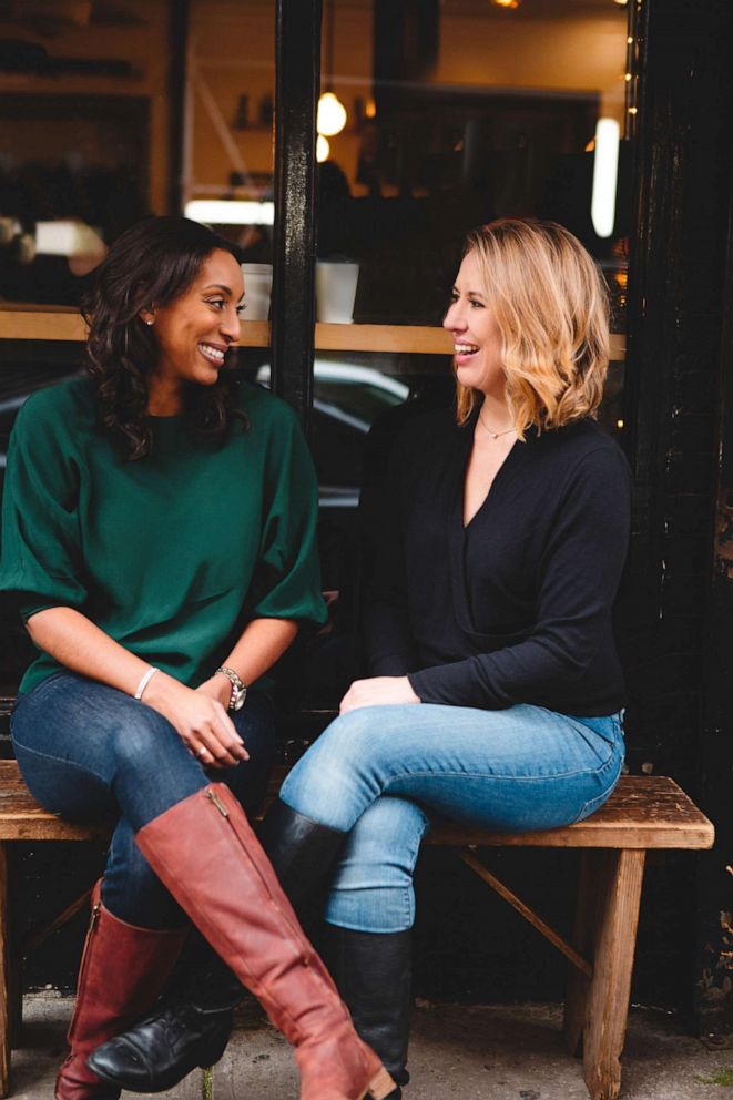 PHOTO: Authors Jo Piazza and Christine Pride sit on a bench as they pose for a photo.