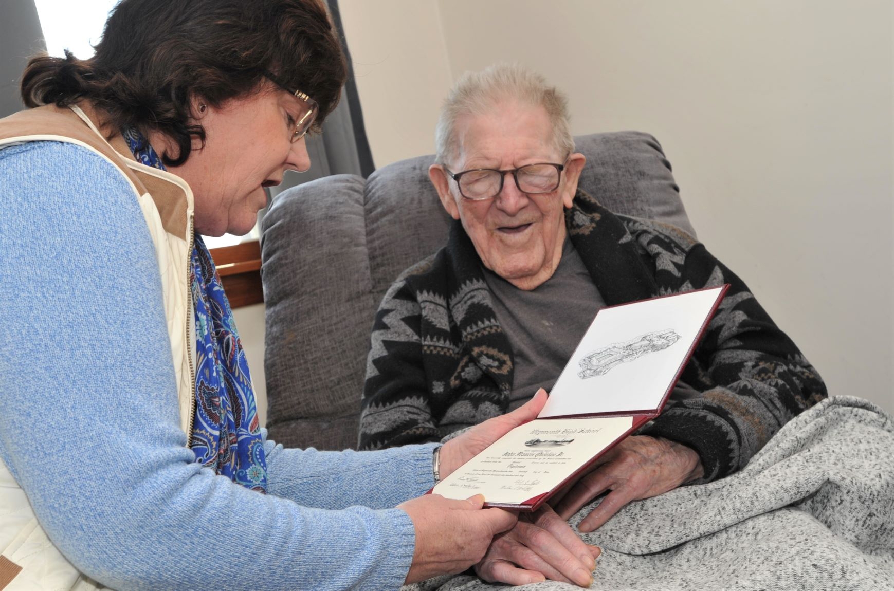 PHOTO: John Quinlan Jr. is presented with his high school diploma by Weymouth School Committee member, Kathy Sullivan Curran on his 99th birthday in his home in Weymouth, Mass., Feb 17, 2020.