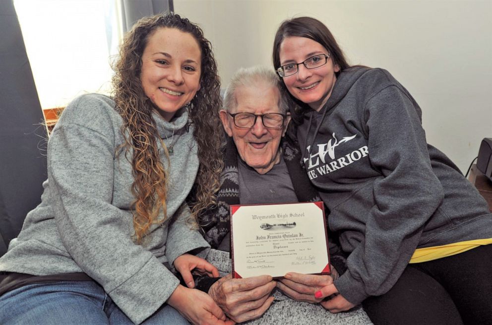 PHOTO: Emily and Elyse Quinlan pose for a photo with their grandfather, John Quinlan Jr., holding his high-school diploma which was given to him in honor of his 99th birthday in Weymouth, Mass., Feb. 17, 2020.