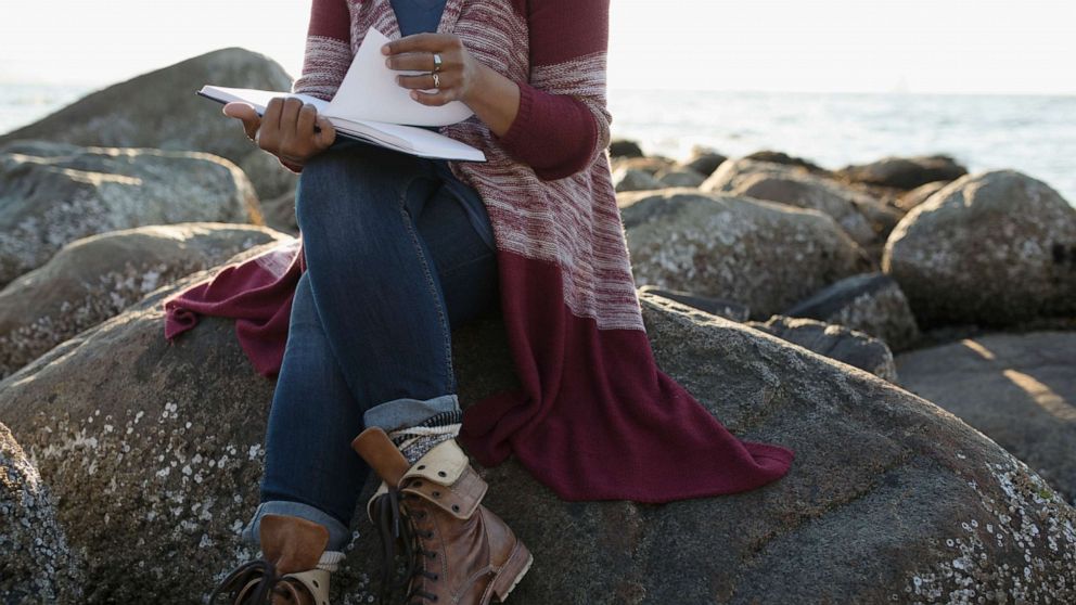 PHOTO: A woman sits on a rock.