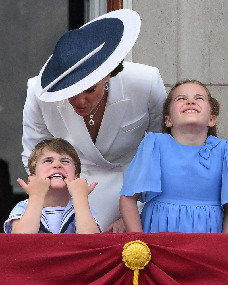 PHOTO: Catherine, Duchess of Cambridge talks to Prince Louis who is pulling a funny face, as they stand with Princess Charlotte of Cambridge to watch a special flypast from Buckingham Palace balcony in London on June 2, 2022.