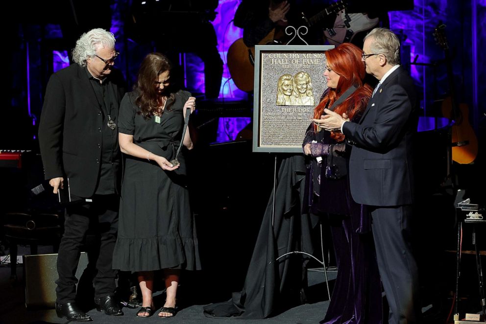 PHOTO: Ashley Judd accepts induction on behalf of Naomi Judd with Ricky Skaggs, left, inductee Wynonna Judd onstage for the class of 2021 medallion ceremony at Country Music Hall of Fame and Museum on May 1, 2022 in Nashville, Tenn.