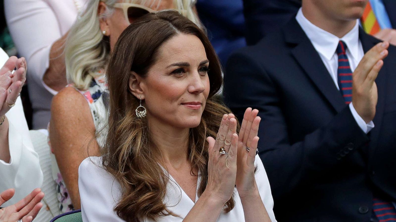 PHOTO: Kate, Duchess of Cambridge applauds after taking her seat in the Royal Box on Centre Court on day two of the Wimbledon Tennis Championships in London, July 2, 2019. At top right is actor Will Poulter.