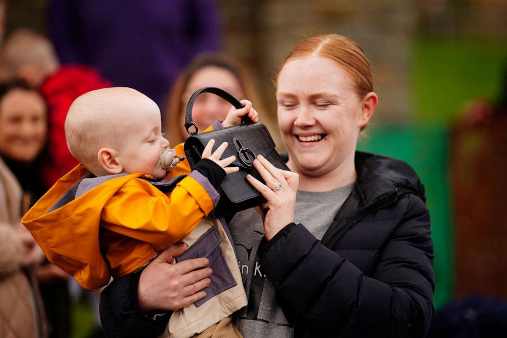 PHOTO: Lucy Williams, from Aberfan, holds her son Daniel Williams as he plays with the handbag of Catherine, Princess of Wales, which he took from her during her visit with Britain's Prince William, Prince of Wales in Aberfan, Wales, Britain on April 28,