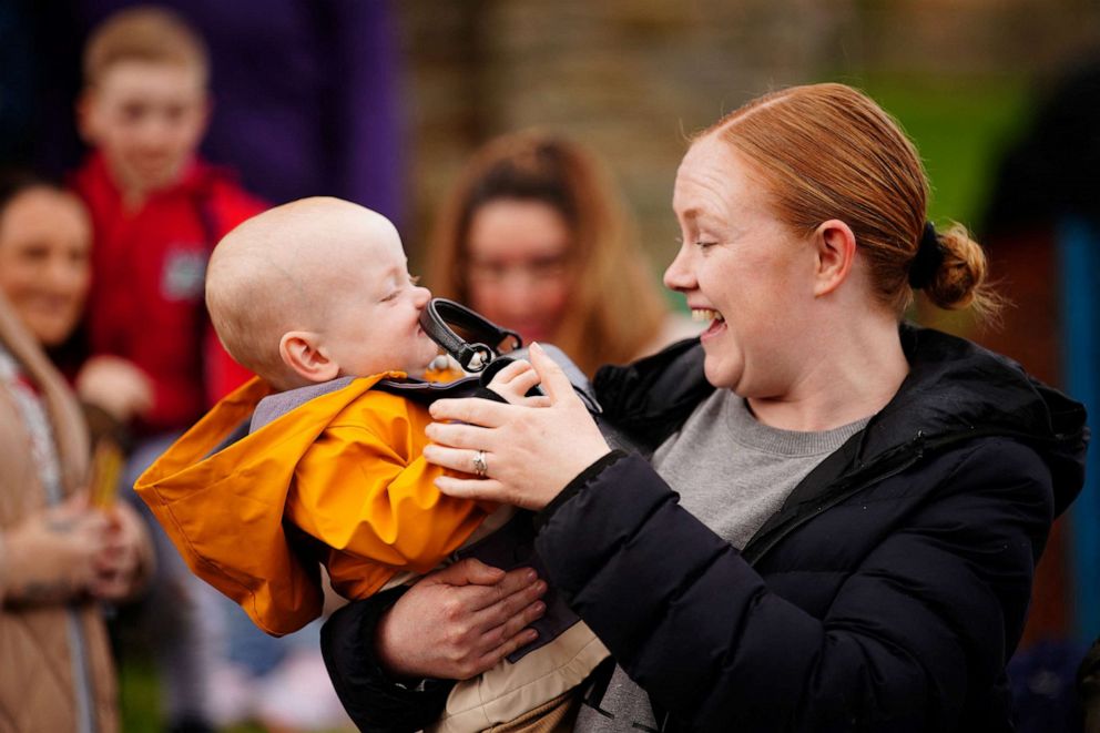 PHOTO: Lucy Williams, from Aberfan, holds her son Daniel Williams as he plays with the handbag of Catherine, Princess of Wales, which he took from her during her visit with Britain's Prince William, Prince of Wales in Aberfan, Wales, Britain on April 28,