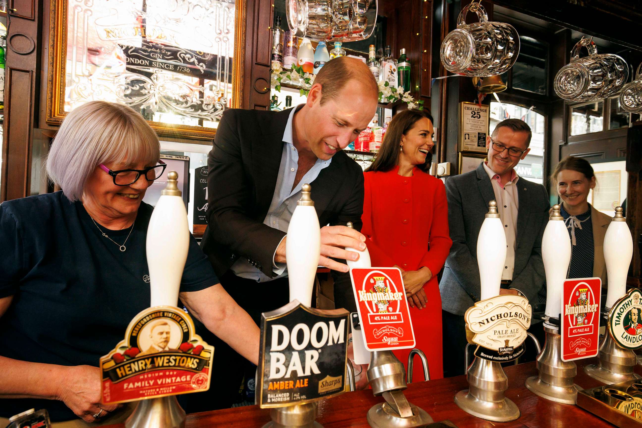 PHOTO: Prince William, Prince of Wales pulls the first pint of Kingmaker a new brew celebrating the coronation as Catherine, Princess of Wales looks on at the Dog and Duck pub in Soho ahead of this weekend's coronation on May 4, 2023 in London.
