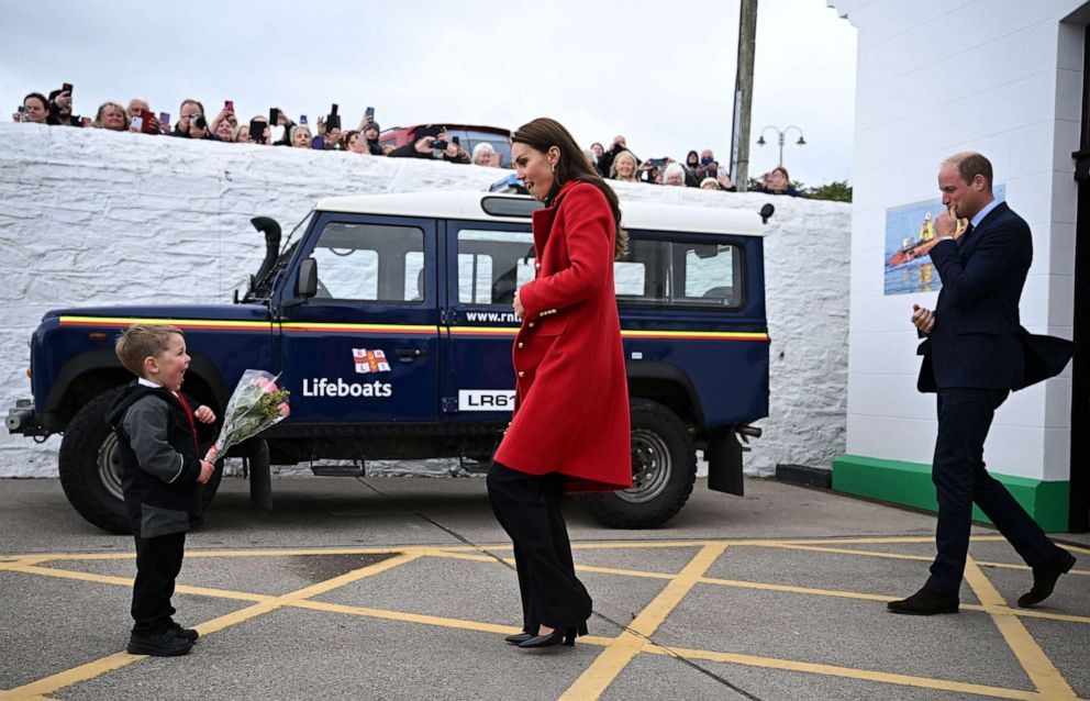 PHOTO: Prince William, Prince of Wales watches as his wife Catherine, Princess of Wales is presented with a posy of flowers by Theo Crompton during their visit to the RNLI Holyhead Lifeboat Station in Anglesey, north west Wales on Sept. 27, 2022.