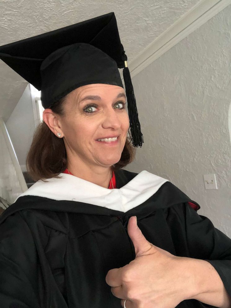 PHOTO: Kathleen Durkin decided to dress in a cap and gown and blast "Pomp and Circumstance" while delivering yard signs to high school seniors on April 24, 2020 in Park Ridge, Illinois.