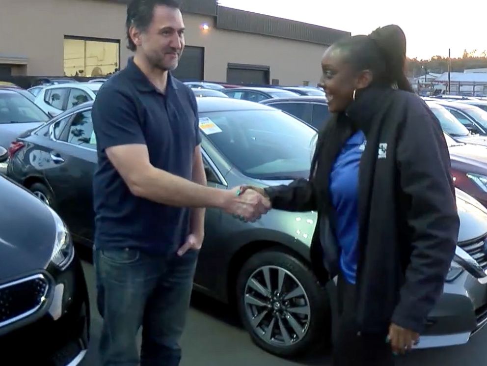 PHOTO: Kayla Cooper, 22, of San Diego, California, shakes hands with Dan Laguardia, 49, after he gave her his 2005 Scion instead of trading it in.