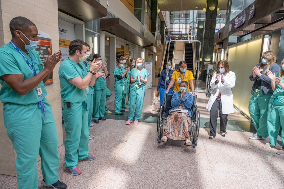 PHOTO: Ochsner Medical Center staff lined the hallways to celebrate on Monday as its 1,500th COVID-19 patient was discharged.
