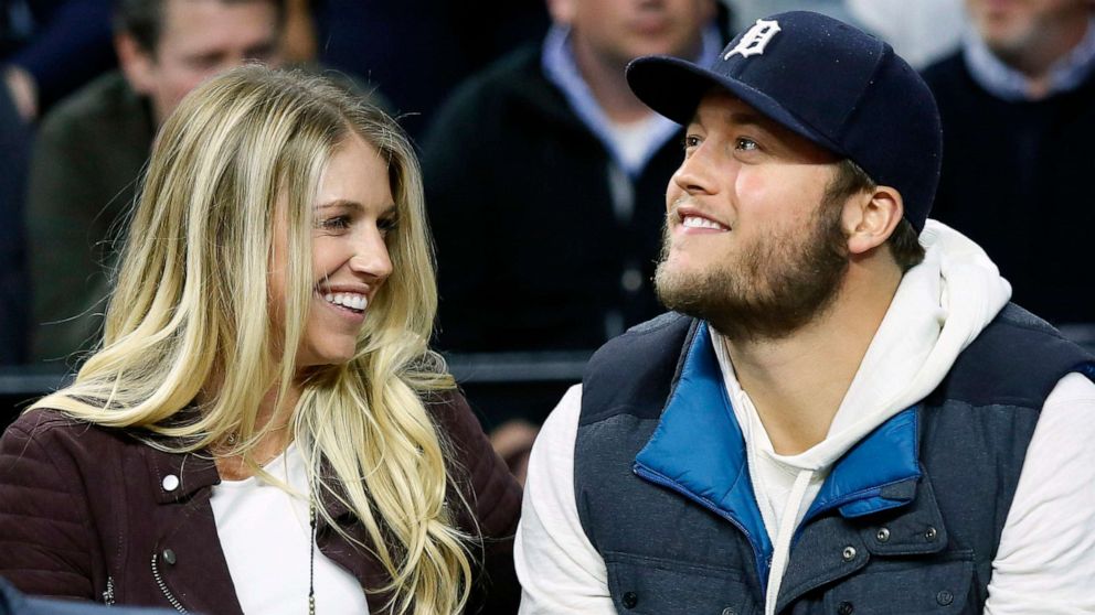In this Nov. 17, 2015, file photo, Detroit Lions quarterback Matthew Stafford, right, smiles while watching the Detroit Pistons play the Cleveland Cavaliers with his wife Kelly, left, during the first half of an NBA basketball game, in Auburn Hills, Mich.