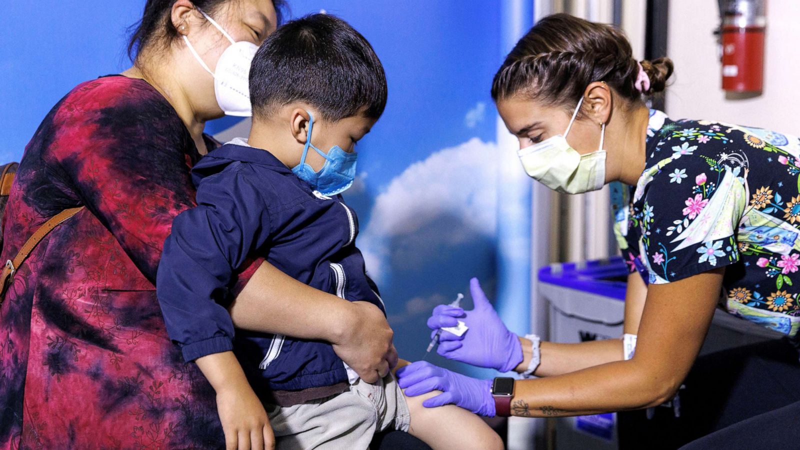 PHOTO: 3 year-old Jake Guojo sits on his mother's lap, as nurse Jillian Mercer administers the Moderna vaccine for the coronavirus disease (COVID-19) at Rady Children's Hospital in San Diego, June 21, 2022.