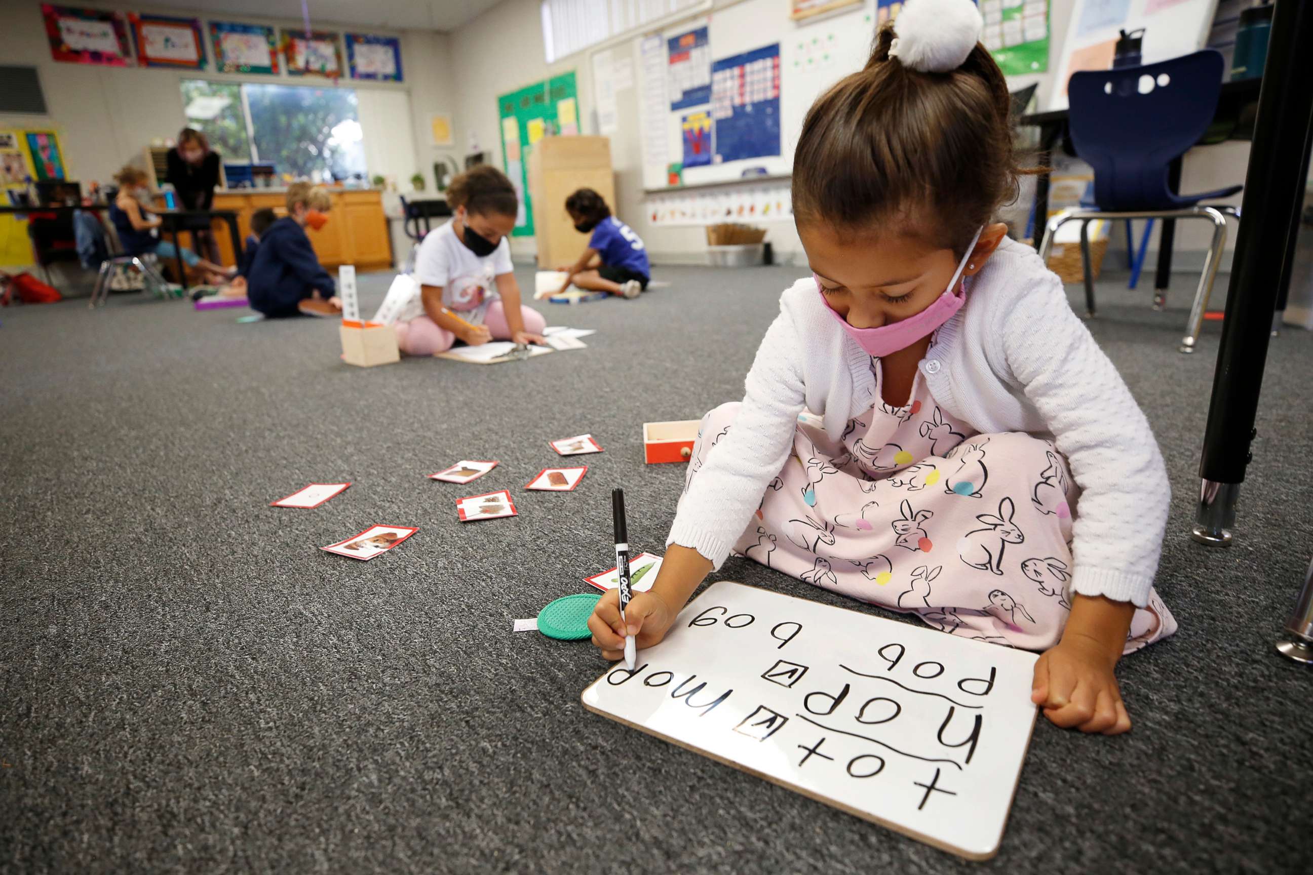 PHOTO: Kindergarten students Amelia Ramirez, front, and Naomi Cooney, back, distance themselves while working in the classroom at Chadwick School in Palos Verdes, Calif., Nov. 5, 2020.