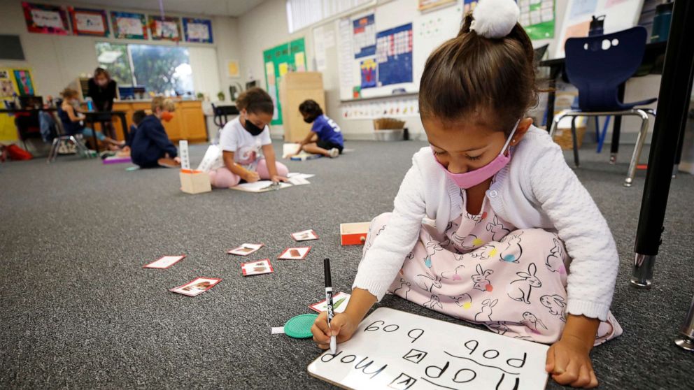 PHOTO: Kindergarten students Amelia Ramirez, front, and Naomi Cooney, back, distance themselves while working in the classroom at Chadwick School in Palos Verdes, Calif., Nov. 5, 2020.