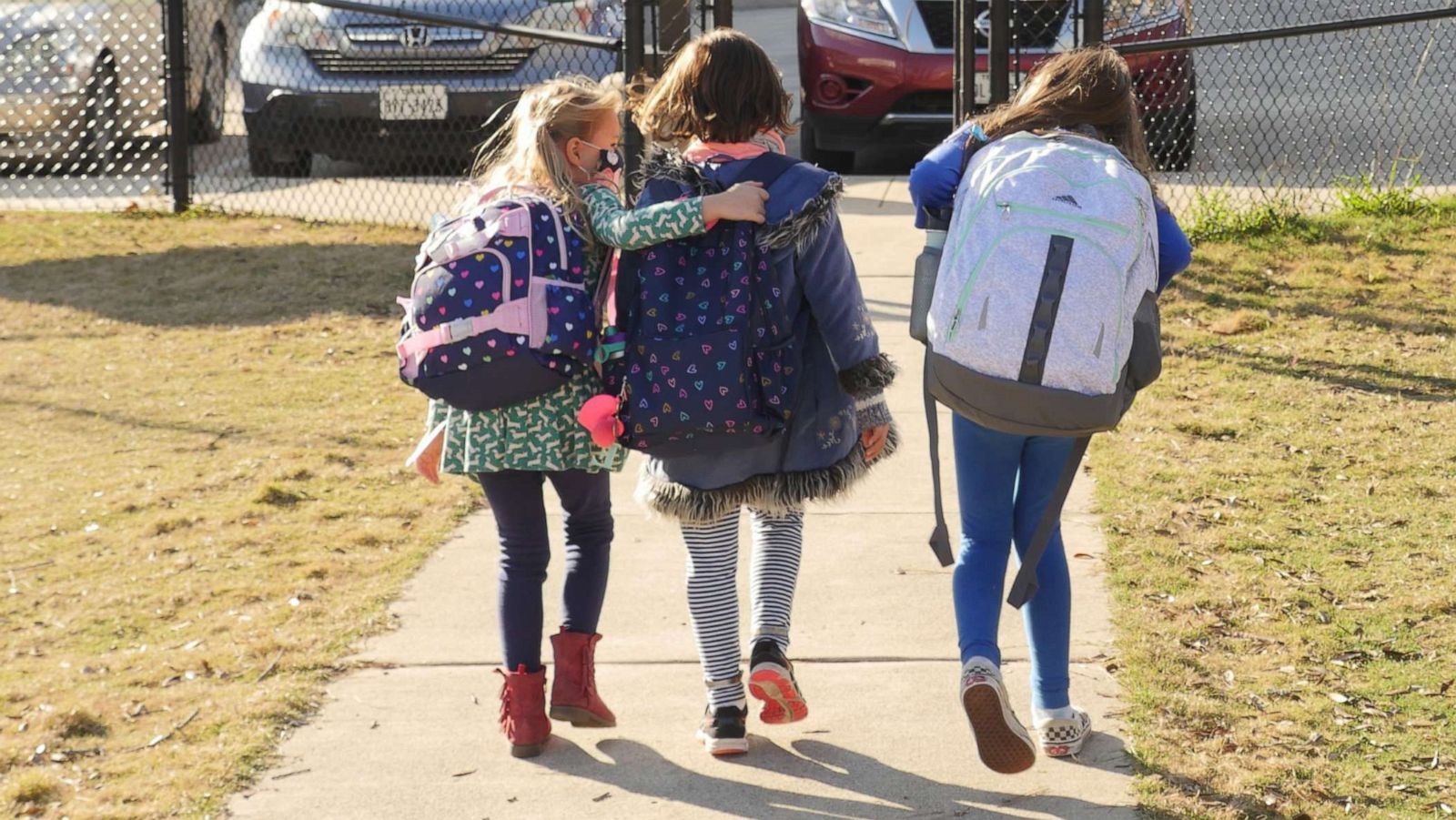 PHOTO: School children wearing facemasks walk outside an elementary school.