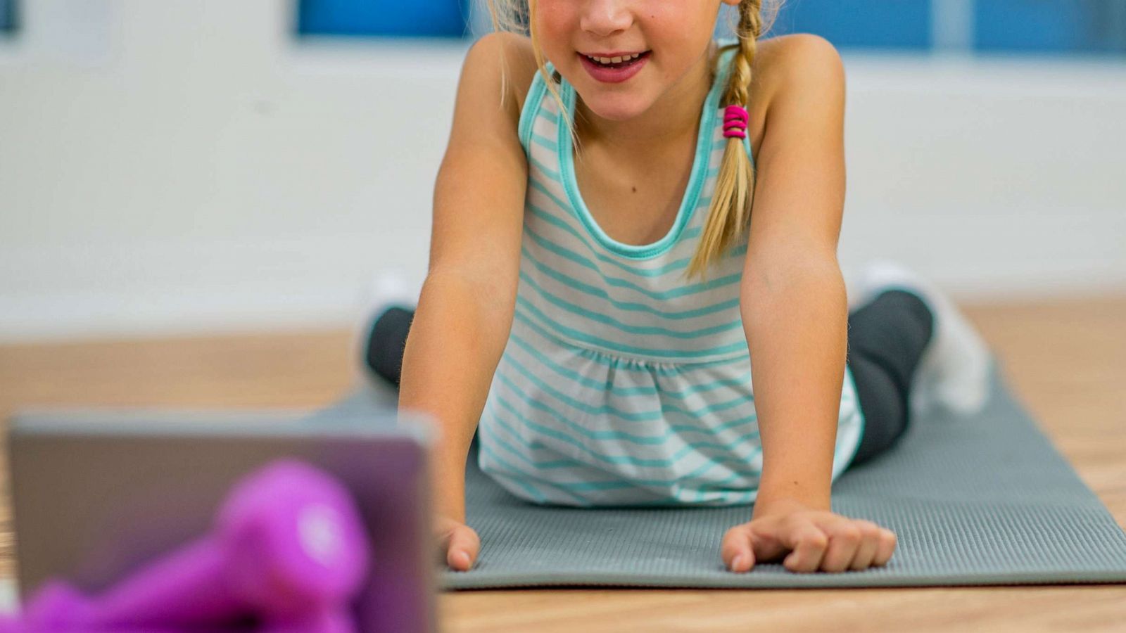 PHOTO: An elementary age girl appears to be doing yoga on an exercise mat.