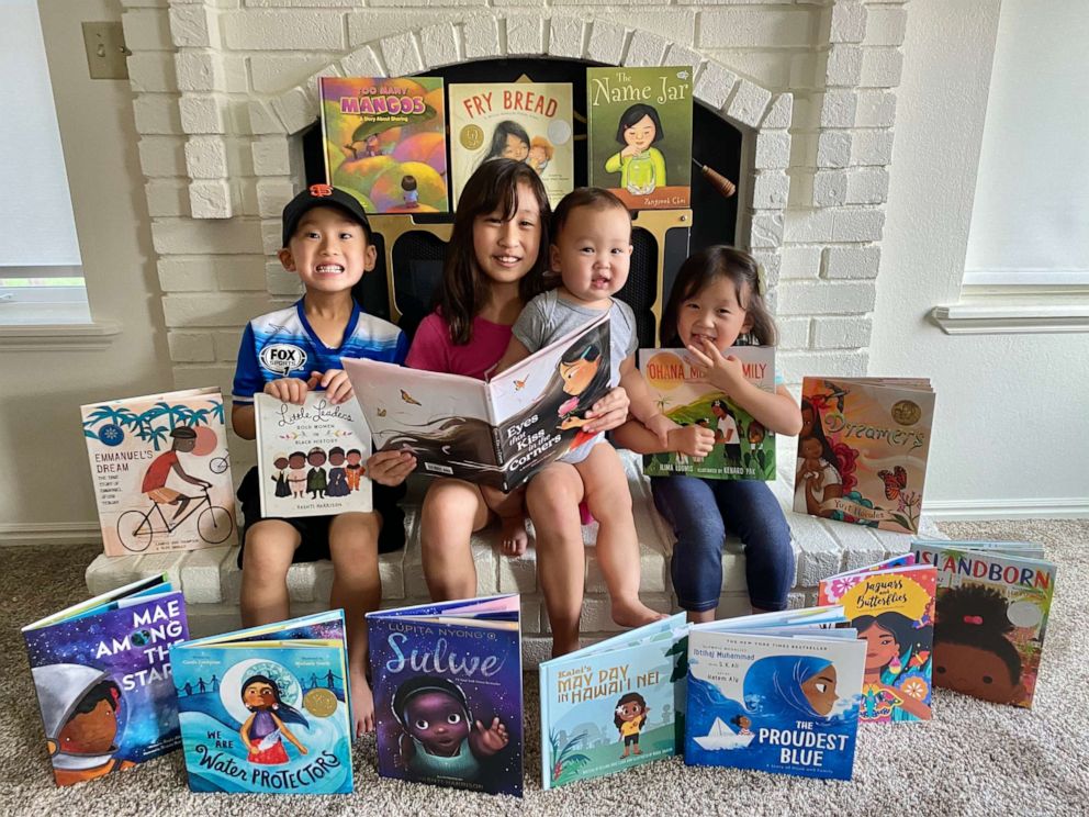 PHOTO: Emi Kim, 9, and her siblings Elliot, Elias, and Evie posing with some of the books purchased with the funds from the lemonade stand.